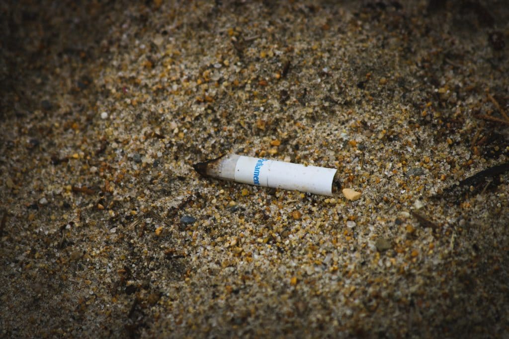 mozzicone di sigaretta lasciato sulla spiaggia