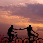 coppia pedala in bicicletta al tramonto