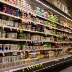 scaffale supermercato pieno di confezioni e barattoli di yogurt