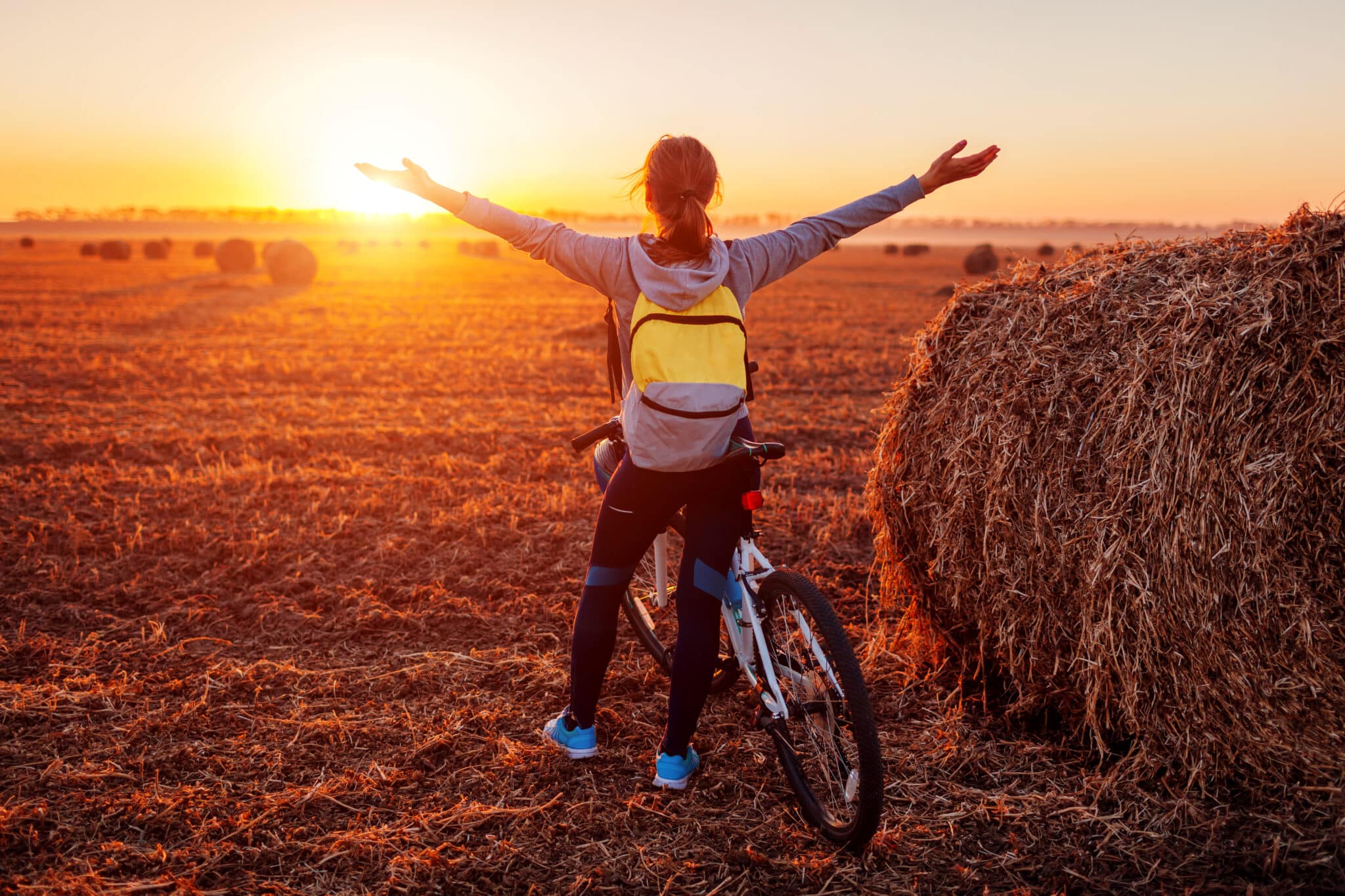 tramonto in campagna con una ragazza felice accanto ad una bicicletta tramonto in campagna con una ragazza felice accanto ad una bicicletta
